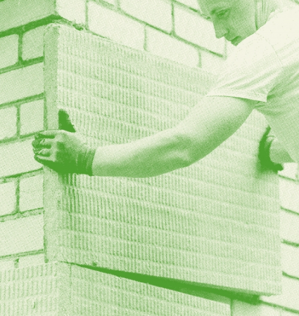 Worker installing an insulating panel in the context of energy work